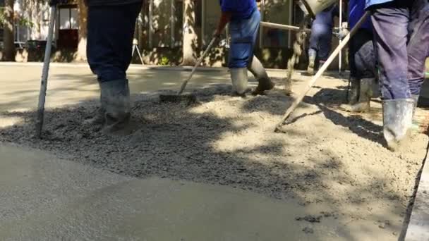Construction Workers Riggers Using Rake Spreading Leveling Concrete Covering Square — Vídeo de Stock