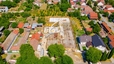 Aerial view on construction site in cityscape, mixer truck pouring concrete into pump machine pumping to exit tube, worker is directing the on right direction, building foundation. 