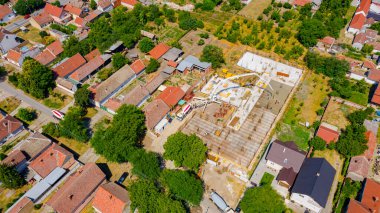 Aerial view on construction site in cityscape, mixer truck pouring concrete into pump machine pumping to exit tube, worker is directing the on right direction, building foundation. 