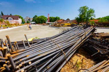 Tied bundles of steel bars reinforcement ready for installation, classified by the bending shape at construction site.