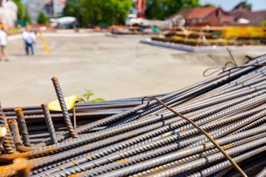 Tied bundles of steel bars reinforcement ready for installation, classified by the bending shape at construction site.