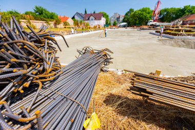 Tied bundles of steel bars reinforcement ready for installation, classified by the bending shape at construction site.