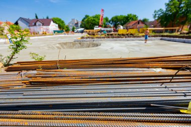 Close up shot of bundles of steel bars reinforcement ready for installation, classified by the bending shape at construction site.