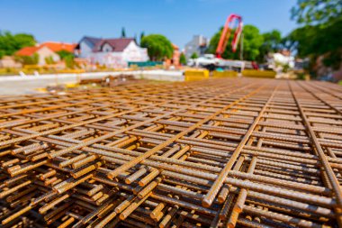 Pile of rusty rectangle steel reinforcement for concrete ready for installation placed at construction site. 