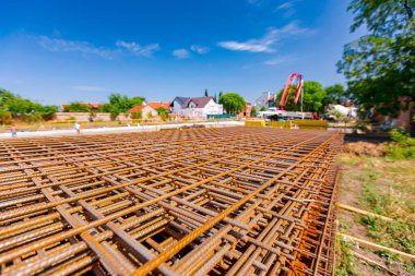 Pile of rusty rectangle steel reinforcement for concrete ready for installation placed at construction site. 