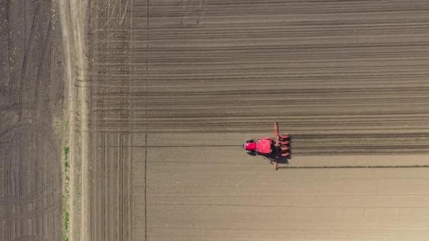 上のビューでは 耕作可能なフィールド 新しいシリアル作物 トウモロコシ トウモロコシの上に機械的なシーダーマシンを引くトラクターの — ストック動画