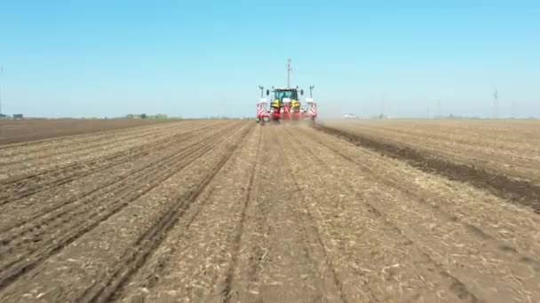 从后面看 从后面低空飞行 拖拉机正在可耕地 种植新的谷类作物 玉米上拉动机械播种机 — 图库视频影像