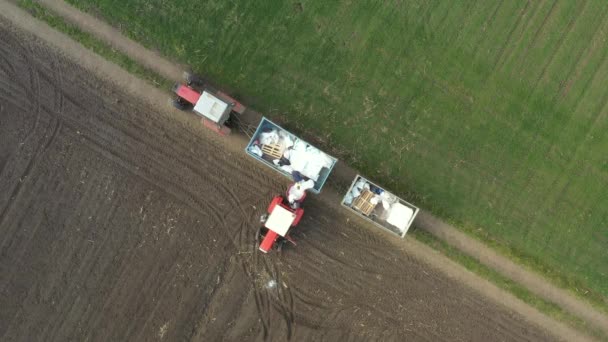 トレーラーから人工肥料をリロードする2人の農家の上のビューでは トラクターに 化学肥料を詰め袋でいっぱい マウントされた 普及のための機械で — ストック動画
