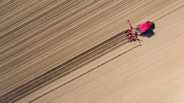 上のビューでは 耕作可能なフィールド 新しいシリアル作物 トウモロコシ トウモロコシの上に機械的なシーダーマシンを引くトラクターの — ストック写真