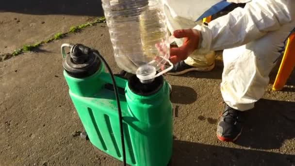 园艺师正在以适当的规模从小袋中配制适当的水和浓缩的提取物 即杀虫剂 杀菌剂等植物溶液 用于早春浇灌果树 — 图库视频影像