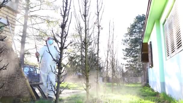 Gärtner Mit Schutzanzug Bestreut Obstbäume Mit Langem Sprühgerät Obstgarten — Stockvideo