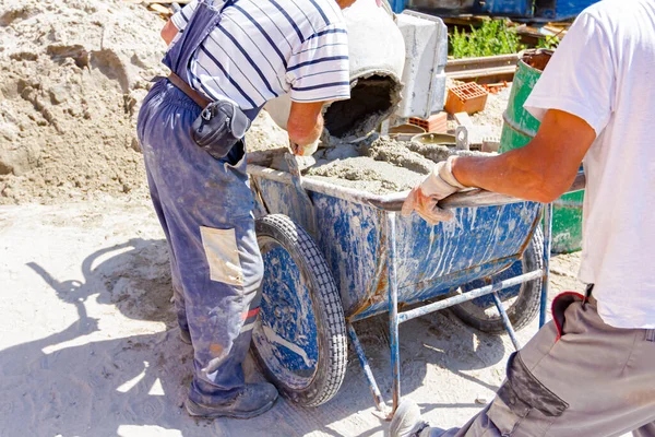 Teamwork Workers Pouring Fresh Mortar Wheelbarrow Mortar Mixer Machine Construction — Stock Photo, Image