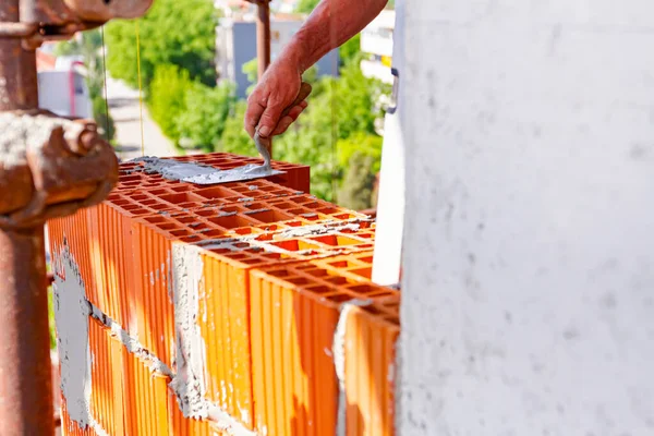 Arbeiter Hält Spachtel Kelle Mörtel Auf Rote Blöcke Aufzutragen Mauerwerk — Stockfoto