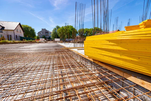 建設中の住宅の具体的な強度のために基礎に配置された錆びた 二次補強 アーマチュア メッシュの視点 塗装黄色の木製の板の山 — ストック写真
