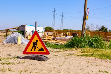 Uyarı sembolü olan üçgen trafik levhası inşaat alanının önüne yerleştirildi..