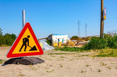 Uyarı sembolü olan üçgen trafik levhası inşaat alanının önüne yerleştirildi..