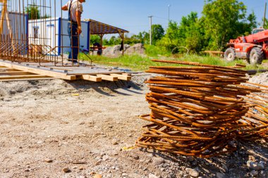İnşaat alanına yerleştirilen paslı ikinci dereceden destek çubukları yığını.