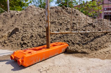 Boş plastik çit ayağı geçici metal tel çit panellerin istikrarı için, caddenin yanındaki inşaat alanının önüne yerleştirilmiş..