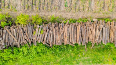 Üstten bakıldığında, sökülmüş eski uykucular, kaldırılmış demiryollarından, büyük yığınlar halinde, taşınmaya hazır..