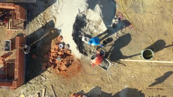 在建筑工地上方 建筑工人正在用铲子把搅拌机灌满 如制造混凝土 — 图库视频影像