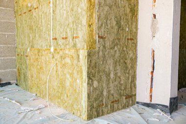 Kapalı duvarın köşesinde bitmemiş termal yalıtım, inşaat halindeki kaya yünü tabakası..