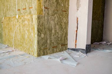 Kapalı duvarın köşesinde bitmemiş termal yalıtım, inşaat halindeki kaya yünü tabakası..