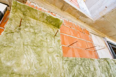 Yeni cephe yapım aşamasında, dış duvar, arasında yalıtım malzemesi gibi lifler, termal yalıtım malzemesi tabakası, bitmemiş yeni bir binanın kaya yünü..