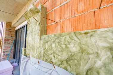 Yeni cephe yapım aşamasında, dış duvar, arasında yalıtım malzemesi gibi lifler, termal yalıtım malzemesi tabakası, bitmemiş yeni bir binanın kaya yünü..