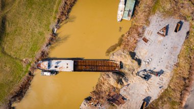 Kazıcının, çekicinin ve römorkörün üzerinde, eski yük gemisinin yatağının bir kısmını çekerken, mavna, nehir kıyısında, kazma, sökme gemisi, kırbaç için metal, geri dönüşüm,.