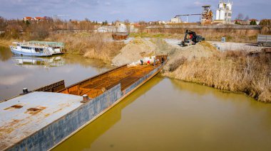 İşçiler eski büyük bir gemiyi keserken, mavnayı parçalara ayırırken, paslı metali kırbaç için keserken, asetilen meşalesi, geri dönüşüm, kıvılcımlar uçuşurken, üst görünümde işçiler görülüyor..