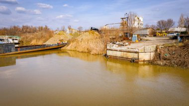 İskele, nehir kıyısındaki beton rıhtımında yığınla eski büyük gemi çöpü, mavna, sökülen gemi parçaları, paslı metali, asetilen meşale, geri dönüşüm, ekipman, benzin deposu,.