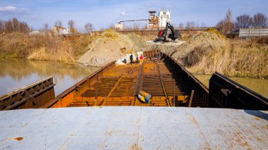 İşçiler eski büyük bir gemiyi keserken, mavnayı parçalara ayırırken, paslı metali kırbaç için keserken, asetilen meşalesi, geri dönüşüm, kıvılcımlar uçuşurken, üst görünümde işçiler görülüyor..
