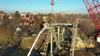 Dolly 'nin tepesinde çalışanlar eski demiryolu köprüsünü kiraz toplayıcıdan geri dönüşüm için asetilen meşalesiyle kesiyorlar. Turna teknede, mavnada, hurda metalde, nehir kıyısına yanaşmış..