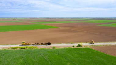 Yukarıda tekerlek üzerinde kazıcı, yakalayıcı el, yakalama pençesi, çoklu valf kapma, sökülmüş eski demiryolu ahşap yatakları almak ve nakliye için onları yük vagonuna yükleme.
