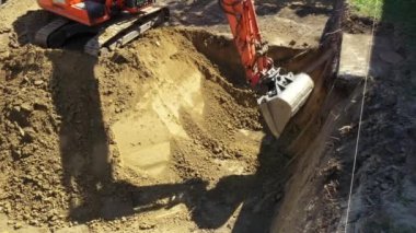 Kazıcının iş aletine yukarıdan bakıldığında, bıçak kazma, yeni konut arazisi için temel kazma, inşaat alanında zemin, devam etmekte olan proje.