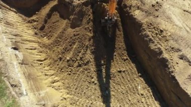 Kazıcının iş aletine yukarıdan bakıldığında, bıçak kazma, yeni konut arazisi için temel kazma, inşaat alanında zemin, devam etmekte olan proje.