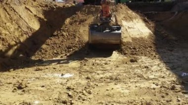 Kazıcının iş aletine düşük görüş, bıçak kazma, yeni yerleşim alanı için temel kazma, inşaat sahasında zemin, devam etmekte olan proje.