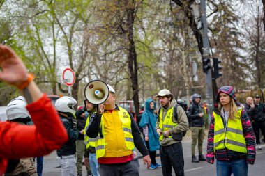 Belgrad, Sırbistan - 15 Mart 2025: Emniyet yeleği giyen öğrenci, hükümet, rejim, çatı çökmesi ve tren istasyonunda hayatını kaybedenler için adalet talebi üzerine megafon, megafon ve megafona konuştu 