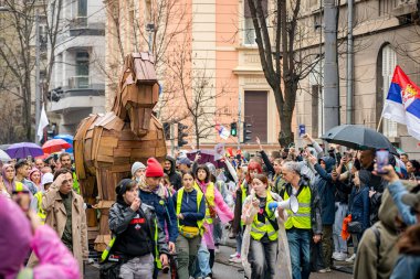 Belgrad, Sırbistan - 15 Mart 2025: Sokaktaki protestocular, hükümeti protesto etmek amacıyla Truva atlarından oluşan bir kalabalığı itip çatıdaki trajik ölümler için adalet istiyorlar