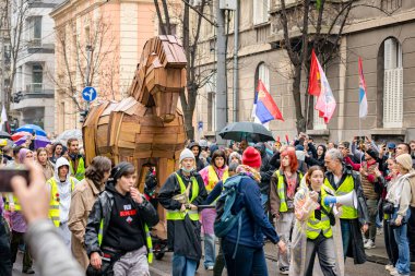 Belgrad, Sırbistan - 15 Mart 2025: Sokaktaki protestocular, hükümeti protesto etmek amacıyla Truva atlarından oluşan bir kalabalığı itip çatıdaki trajik ölümler için adalet istiyorlar