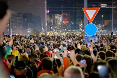 Belgrad, Sırbistan - 15 Mart 2025: Pek çok kişi cep telefonunu kaldırdı, cep telefonu el feneri kullandı, kurbanları onurlandırdı, 15 dakikalık saygı duruşunda bulundu