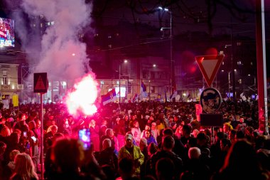Belgrad, Sırbistan - 15 Mart 2025: Elinde yanan fişek tutan kalabalıktan bir adam, kırmızı meşaleyi mor, kırmızı duman çıkarırken yaktı. Öğrenciler, vatandaşlar hükümete ve rejime karşı protesto