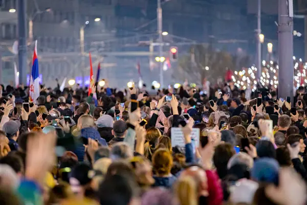 Belgrad, Sırbistan - 15 Mart 2025: Pek çok kişi cep telefonunu kaldırdı, cep telefonu el feneri kullandı, kurbanları onurlandırdı, 15 dakikalık saygı duruşunda bulundu