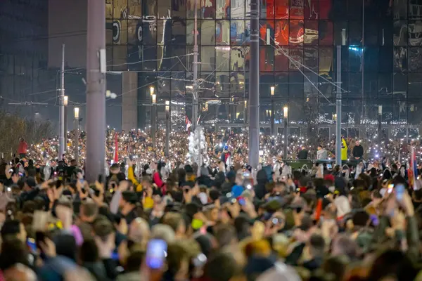 Belgrad, Sırbistan - 15 Mart 2025: Pek çok kişi cep telefonunu kaldırdı, cep telefonu el feneri kullandı, kurbanları onurlandırdı, 15 dakikalık saygı duruşunda bulundu