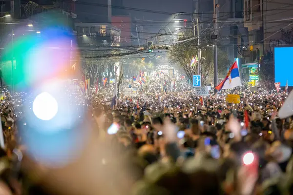 Belgrad, Sırbistan - 15 Mart 2025: Pek çok kişi cep telefonunu kaldırdı, cep telefonu el feneri kullandı, kurbanları onurlandırdı, 15 dakikalık saygı duruşunda bulundu