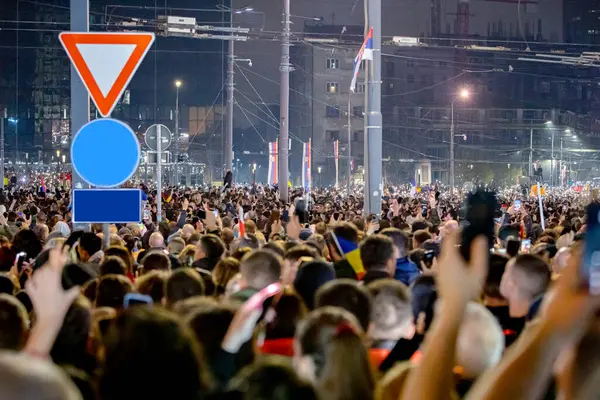 Belgrad, Sırbistan - 15 Mart 2025: Pek çok kişi cep telefonunu kaldırdı, cep telefonu el feneri kullandı, kurbanları onurlandırdı, 15 dakikalık saygı duruşunda bulundu