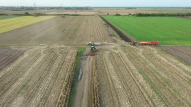 Traktörlü çiftçi manzarasının üzerinde tarımsal makine, disk harrow, kırsal yolda, çiftçilerle konuşmak için durdu. Karavanlı iki traktör transferi bekliyor..