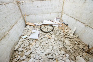 İnşaat kuyusu ezilmiş beton, çöp, güçlendirilmiş tünel çukuru ve asansörde inşa edilecek bir yer ile dolu..