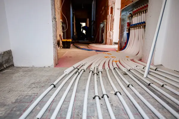 New brass distribution system manifold valves are mounted for central heating floor in a residential building under construction.