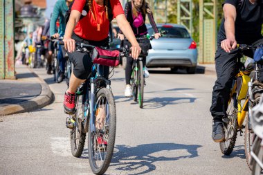 Bisiklet süren, şehirde bisiklete binen, kalabalık içinde araba kullanan bir grup genç, trafikteki ve kentsel çevredeki bisikletçiler için tehlikelere dikkat çekmeye çalışıyor.. 